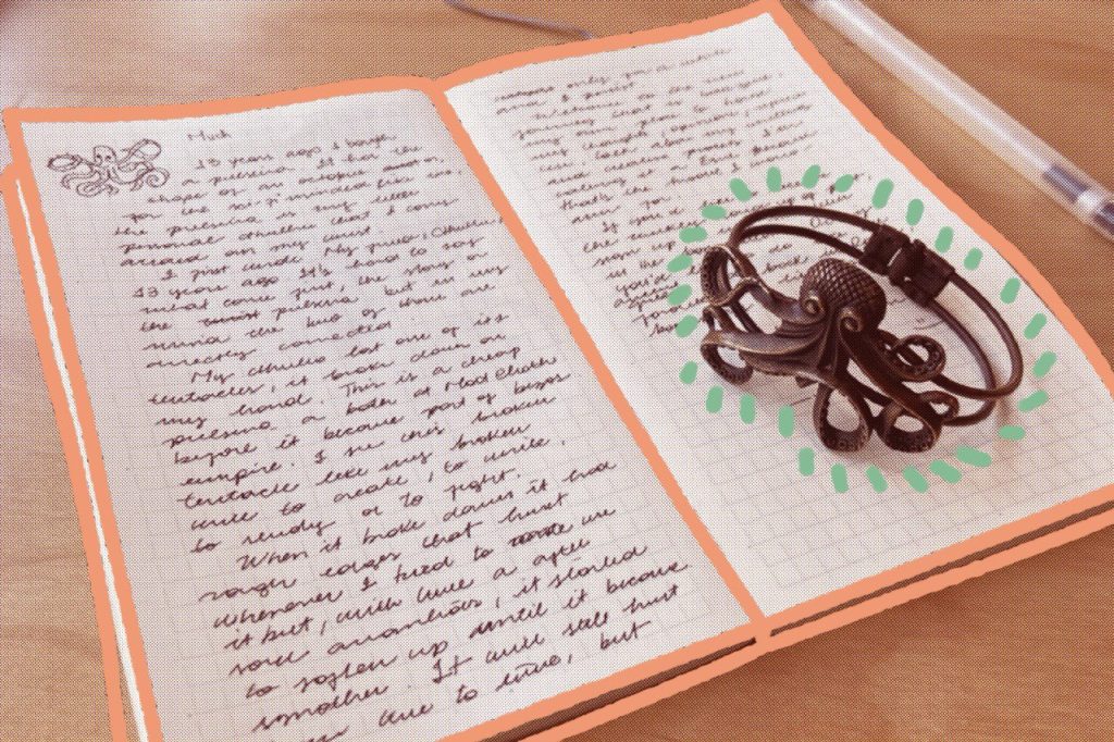 A small notebook is open, with ineligible text written in both. Above the notebook, a cthulhu-shapped metal bracelet (certainly less impressive than the one you are imagining, I'm sorry).